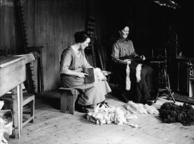 Shetland Spinning and cairding. Andrina Petrie and her mother Barbara Petrie (nee Tait) carding and spinning. Stretchers along wall, large sock brods, Shetland scarf.